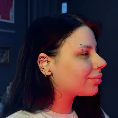 Тату-мастер: лайноворк-орнамент на ухе, профиль клиента