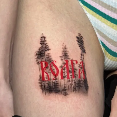 Тату в Тольятти: лесной силуэт и красная надпись «ВОЛГА»