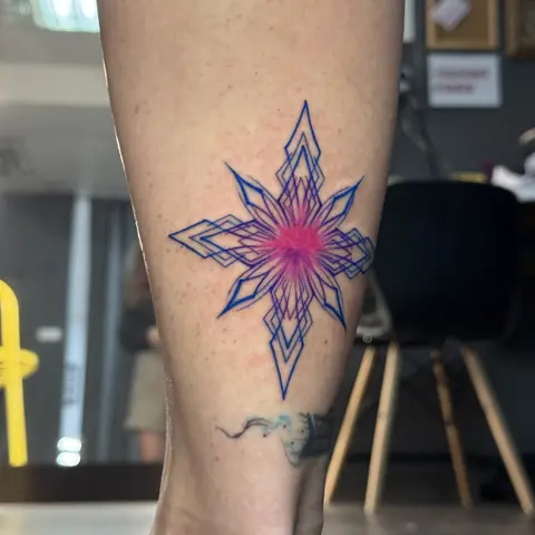 Тату на икре: геометрическая снежинка, синий контур и розовый центр
