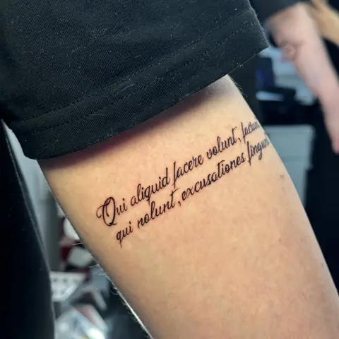 Тонкая тату-надпись на бедре на латыни, аккуратная каллиграфия