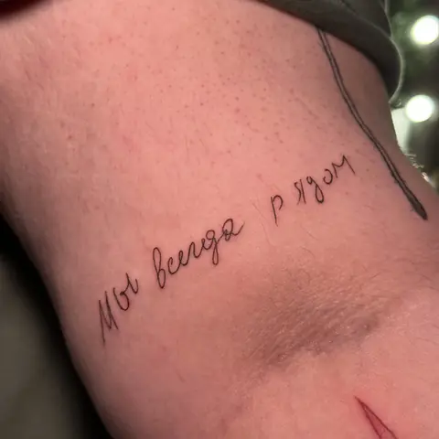 Тату-надпись курсивом: «Мы всегда рядом», минимализм