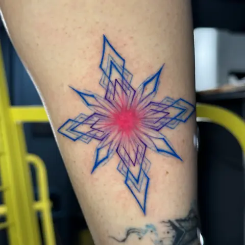 Тату на голени: геометрическая звезда, синий контур и розовый центр